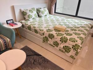 a bedroom with a bed with a green and white comforter at Vinhome Grand Park Homestay-HappyStay in Gò Công