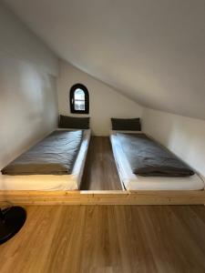 two beds in a small room with a window at Ferienwohnung Zum Fiaker in Garmisch-Partenkirchen
