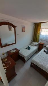 una camera con due letti, uno specchio e un lavandino di Casa Tre Fiori 2 a Serra Rocco