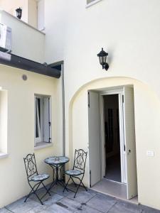 a patio with two chairs and a table next to a building at Mazzini Stay in Gorizia