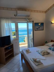 a bedroom with a bed and a view of the ocean at Apartmani Šperanda Pisak in Pisak