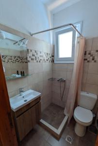a bathroom with a sink and a toilet and a window at Guesthouse Christos in Skopelos Town