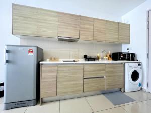 a kitchen with a refrigerator and a washing machine at Dino Homes at i-City - WiFi TV Box 1 Carpark in Shah Alam
