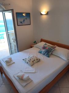 a bed with white sheets and pillows on it at Apartmani Šperanda Pisak in Pisak