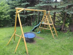 a playground with a swing and a ladder at Dom na Karkonoskiej in Karpacz