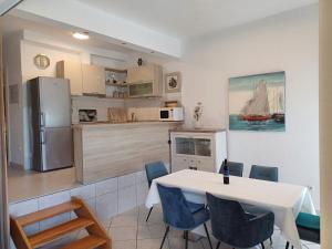a kitchen and dining room with a white table and chairs at Apartmani Šperanda Pisak in Pisak