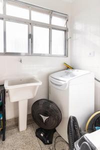 a bathroom with a washing machine and a sink at Vista para o Mar & Pé na Areia in São Vicente +10 photos