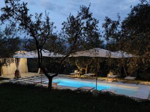 a swimming pool with a tent and a table and chairs at Casa Vacanze Malvarosa in Spigno Saturnia