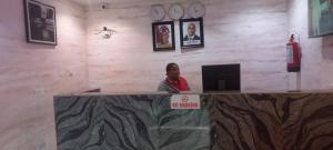 Eine Frau, die an einem Tresen in einer Bar sitzt. in der Unterkunft Estad hotel in Benin-Stadt