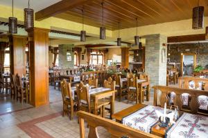 Pensjonat Maria 5 في زاكوباني: غرفة طعام مع طاولات وكراسي خشبية