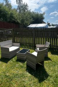 two chairs and a bench in a yard next to a fence at Superb Two Bedroom House Near Etihad & Coop Live - Free Parking in Manchester