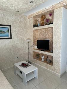 een woonkamer met een tv en een witte tafel bij PARADISE Apartments in Dobrota