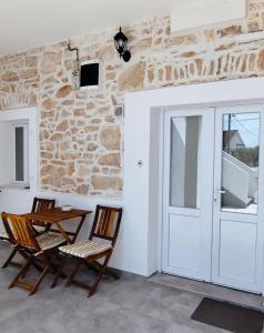 2 chaises et une table dans une chambre avec porte dans l'établissement Heritage Studios Sukosan Center, à Sukošan