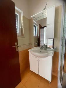 a bathroom with a white sink and a mirror at Apartmani Baki in Podstrana +40 photos
