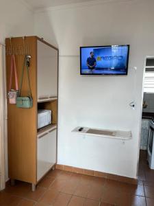 a kitchen with a tv hanging on the wall at Apartamento São Vicente in São Vicente