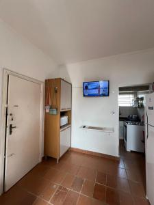 a kitchen with a refrigerator and a tiled floor at Apartamento São Vicente in São Vicente
