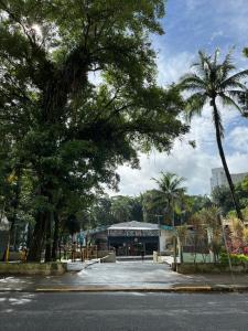 a bus is parked in a parking lot with trees at Apartamento São Vicente in São Vicente