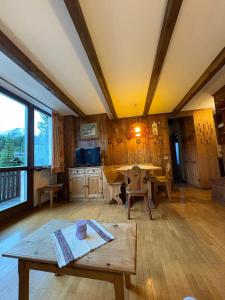 a living room with wooden walls and a table at Appartamento Vistabella in Livigno +14 photos