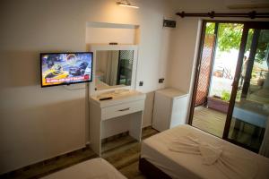 a room with a tv and a bed and a mirror at THE SANDHİLl OTEL RESTAURANT in Kemer