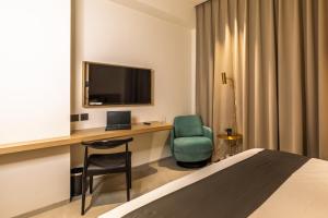 a hotel room with a desk with a television and a chair at Hotel Starlight by Avana, 400m from US Consulate Hyderabad in Hyderabad