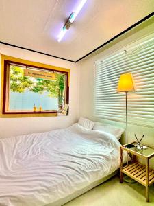 a bedroom with a white bed and a window at Konkuk-SeongSu Goznuk Stay in Seoul