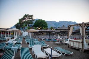 a group of lounge chairs and umbrellas on a beach at THE SANDHİLl OTEL RESTAURANT in Kemer