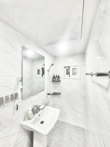 a white bathroom with a sink and a shower at Konkuk-SeongSu Goznuk Stay in Seoul