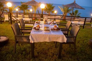 a table with food on it with chairs and the ocean at THE SANDHİLl OTEL RESTAURANT in Kemer