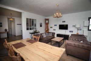 a living room with a wooden table and a couch at Maison en bois Baie de Somme in Saint-Blimont