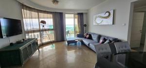 a living room with a couch and a tv at New on booking Top Class Excluzive Luxury De -Golf Resort in Eilat