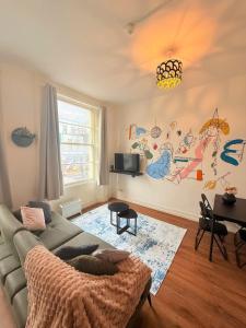 a living room with a couch and a mural on the wall at Flat In Stokes Croft in Bristol