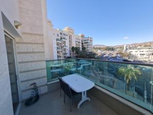 a balcony with a table and a view of a city at New on booking Top Class Excluzive Luxury De -Golf Resort in Eilat