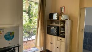 a kitchen with a microwave on a shelf with a window at Casa LeValois - Hidden Garden Oasis in Port-Louis in Port Louis
