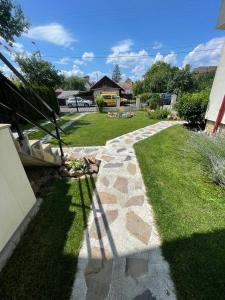 a garden with a stone path in the grass at Casa Vonvea in Ocna Şugatag