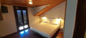 a bedroom with a bed with two pillows and a window at Afouteza in Pontevedra
