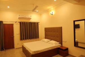 a small bedroom with a bed and a mirror at Hotel Times Stay in Udaipur