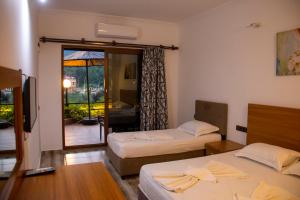 a hotel room with two beds and a balcony at THE SANDHİLl OTEL RESTAURANT in Kemer