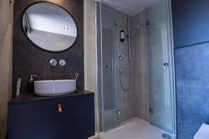 a bathroom with a sink and a shower with a mirror at Tatra Glamp Okrzeszyn - Siec noclegowa Tatra Glamp in Okrzeszyn +49 photos