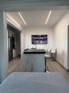 una camera con cucina con lavandino e TV a parete di Suite Stella Luxe Mazzini park a Lido di Jesolo