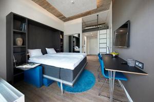 1 dormitorio con cama, escritorio, cama y mesa en Living Suites en Nærum