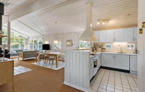 a kitchen with white cabinets and a dining room at 3 Bedroom Stunning Home In Blokhus in Blokhus