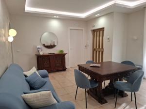 Una sala de estar con un sofá azul y una mesa. en Agrigento tra templi e mare 2, en Agrigento