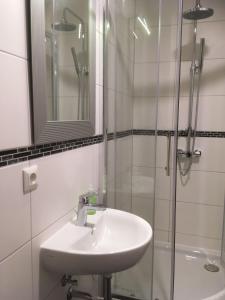 ein weißes Badezimmer mit Waschbecken und Dusche in der Unterkunft Hotel M68 in Berlin + 46 Fotos