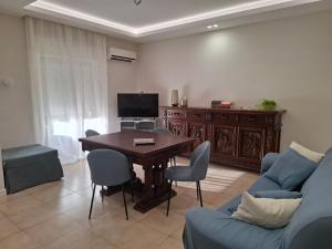 Una sala de estar con una mesa y un sofá azul. en Agrigento tra templi e mare 2, en Agrigento