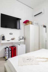 a room with two refrigerators and a tv on the wall at EnSe Affittacamere in Tortolì