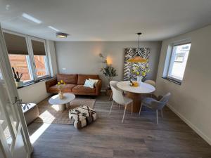 a living room with a table and a couch at Nieuw in 2025 Bundi Coast Vakantiehuis bij Strand & Duinen in Egmond aan Zee