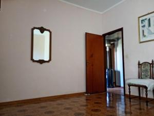 an empty room with a mirror and a chair at Santi Palace Apartment in Gravina di Catania