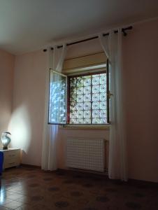 a room with a window with curtains and a radiator at Santi Palace Apartment in Gravina di Catania
