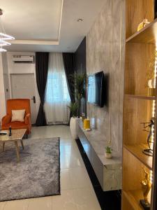 un salon avec un canapé et une télévision dans l'établissement Peridot Lush Apartment Wuye, Utako Abuja, à Abuja