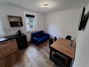Lewin KłodzkiNoclegi przy Wiadukcie - Apartamenty的客厅配有桌子和蓝椅